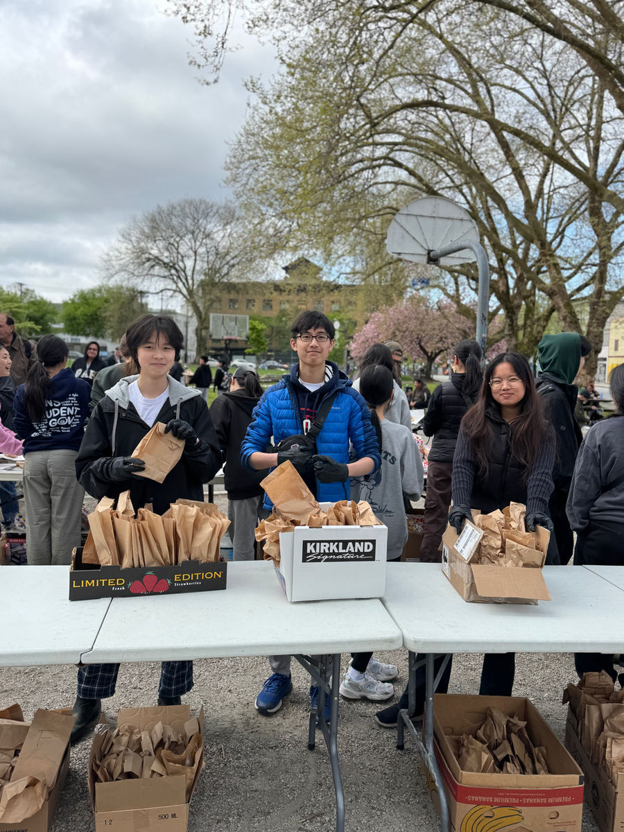 Volunteers holding paper bags of care packages ready to be handed out