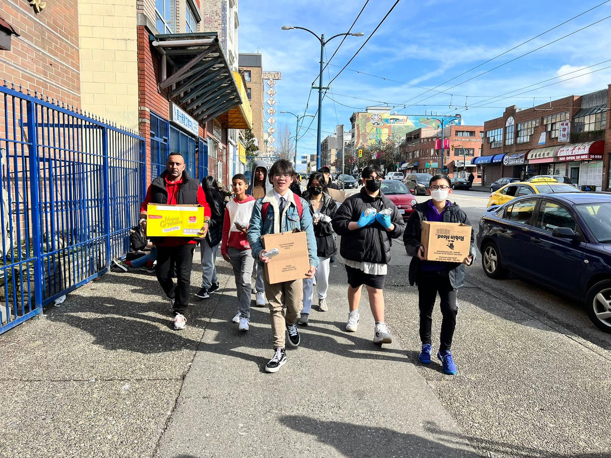 Helping Hearts volunteers carrying boxes of donations along a Vancouver street