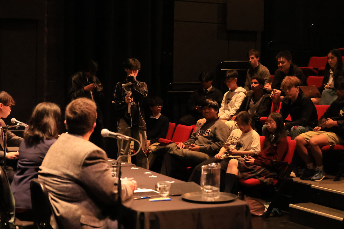Youth delegates in discussion around a microphone table at a conference session